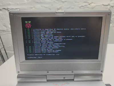 A portal DVD player with a blurry screen, displaying Linux boot messages and a login prompt.